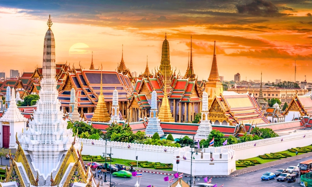 Cảnh hoàng hôn rực rỡ tại Hoàng Cung Thái Lan với những ngọn tháp mạ vàng và mái chùa lấp lánh dưới ánh nắng cuối ngày
