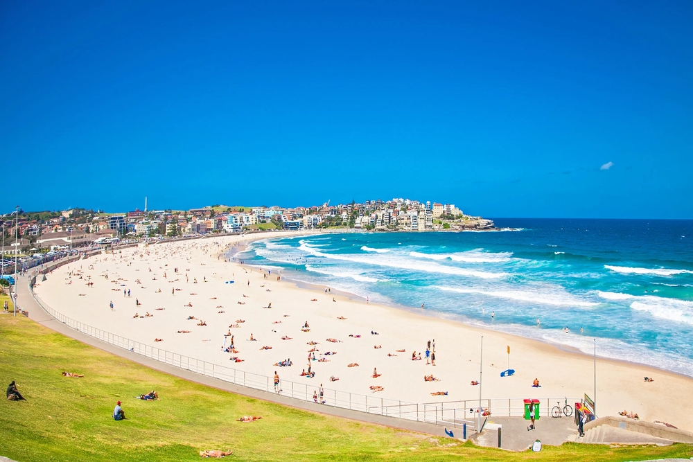 Bãi biển Bondi rực rỡ trong nắng hè, là điểm đến lý tưởng để tắm nắng, lướt sóng và tận hưởng không khí biển sôi động