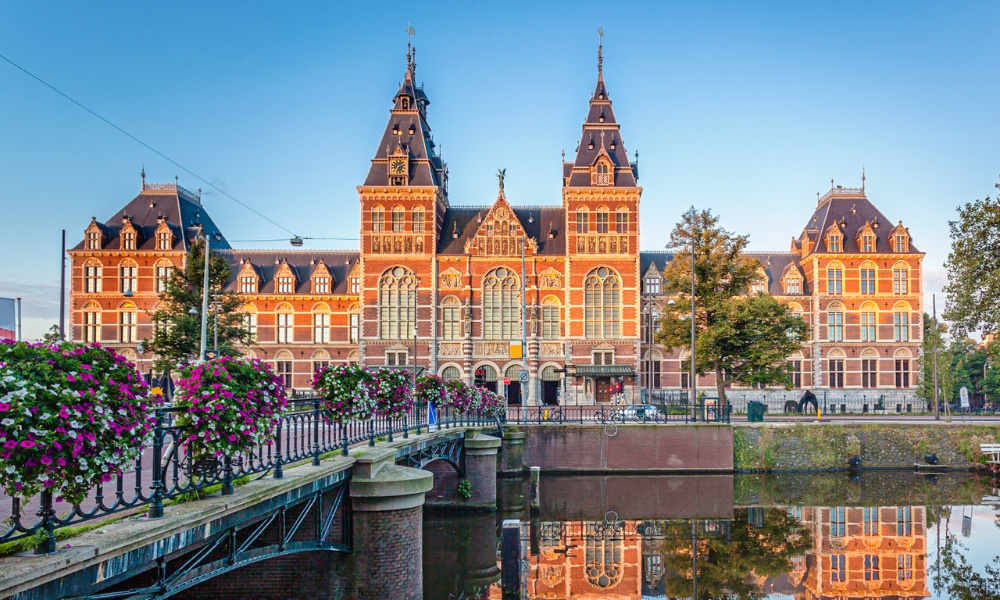 Bảo tàng Rijksmuseum nổi bật giữa nền trời xuân trong trẻo, rực rỡ sắc hoa trước lối vào cổ kính