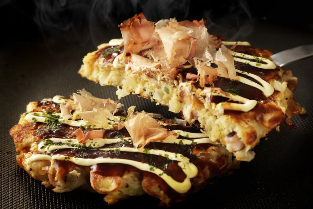 Okonomiyaki v&agrave;ng ruộm, đầy ắp nh&acirc;n v&agrave; được rưới sốt đậm đ&agrave;