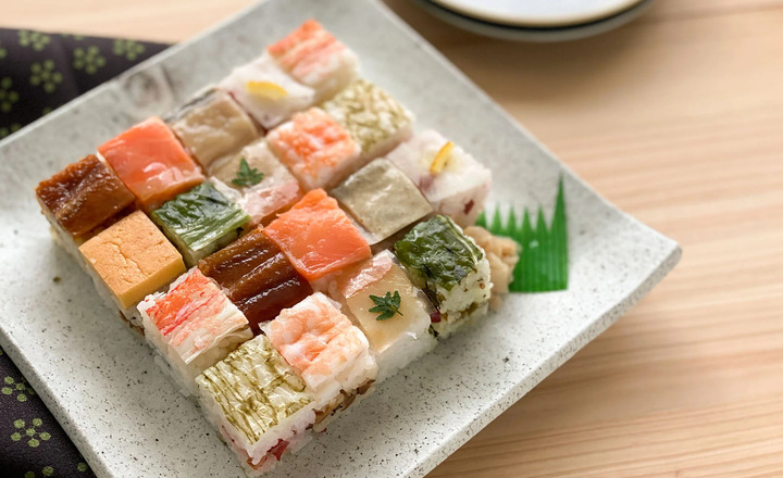 Hakozushi với nguyên liệu được ép vào trong một hộp gỗ hình vuông cắt thành những khối đẹp mắt