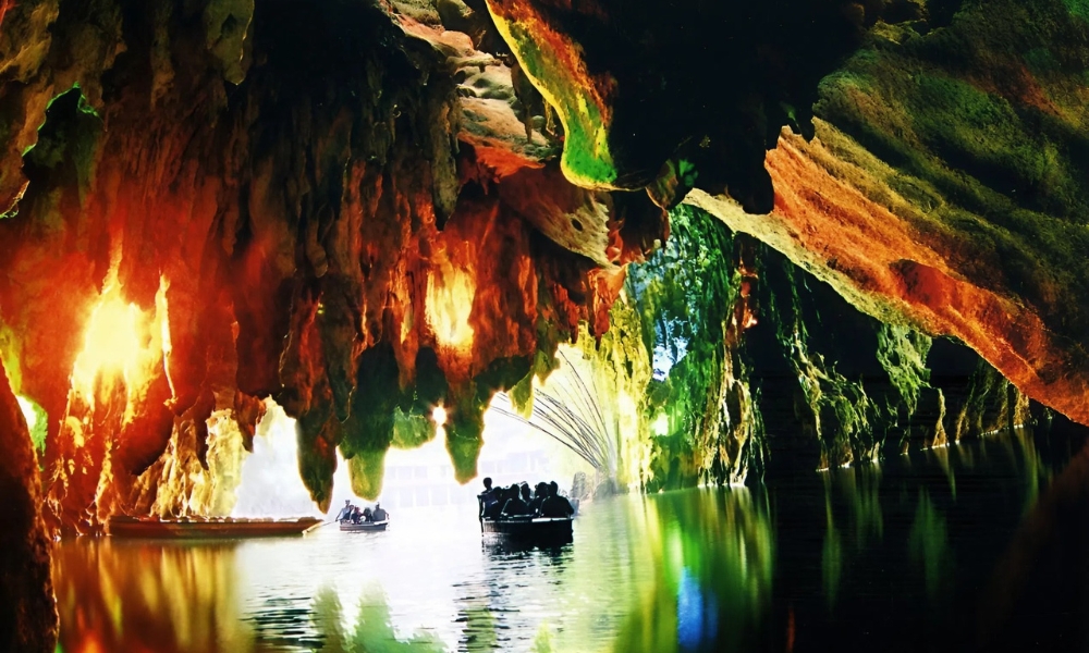 Khung cảnh kỳ ảo b&ecirc;n trong hang động Long Cung với thạch nhũ lấp l&aacute;nh v&agrave; d&ograve;ng s&ocirc;ng ngầm uốn lượn giữa l&ograve;ng n&uacute;i